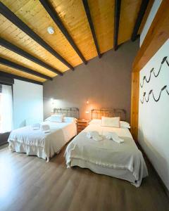a bedroom with two beds in a room at Casa del Tío Marcelo in Pedraza-Segovia