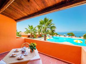 a table on a balcony with a view of a pool at Torre Sant'Irene Club in Sant'Irene-Briatico