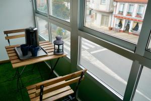 a table with two mugs on it next to a window at Apartamentos Campus Arzúa in Arzúa