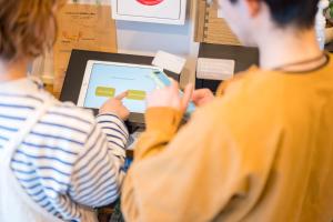 two people are looking at a computer screen at wanderlust STAY in Kofu