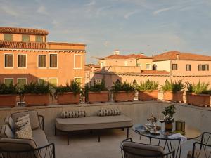a patio with a bench and tables on a balcony at Violino d'Oro Venezia in Venice