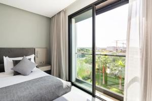 a bedroom with a bed and a large window at Makass Appart Hotel in Rabat +56 photos