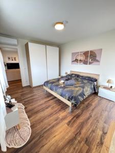 a bedroom with a bed and a wooden floor at Satori House in Sanremo