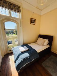 a bed in a room with a large window at Nethercoombe House in Portland
