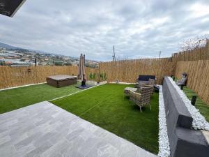 a small backyard with a lawn and a fence at Satori House in Sanremo