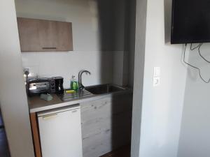 una piccola cucina con lavello e forno a microonde di El Mar Studios a Keramotí