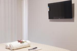 a room with a towel and a tv on a wall at Pousada Porto Maresias in Cabo Frio