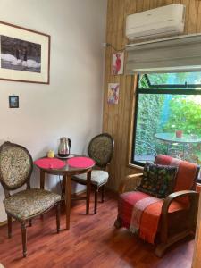 a living room with a table and chairs and a window at TINY HOUSE EL ROBLE in Puerto Varas