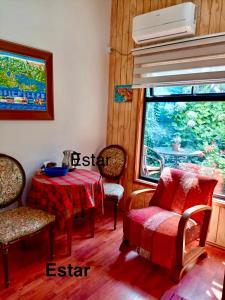 a dining room with a table and chairs and a window at TINY HOUSE EL ROBLE in Puerto Varas