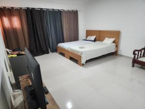 a bedroom with a bed and a flat screen tv at Soares Stay in Tarrafal +9 photos