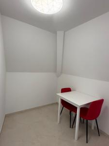 ein weißer Tisch und zwei rote Stühle in einem Zimmer in der Unterkunft Traumwelt in Flemlingen + 36 Fotos