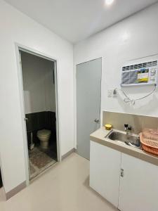 a white kitchen with a sink and a toilet at SiS B&B in San Jose