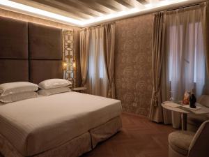 a bedroom with a white bed and a table and curtains at Hotel Antiche Figure in Venice +116 photos