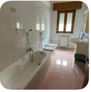 a white bathroom with a tub and a sink at A un passo dal centro in Salemi