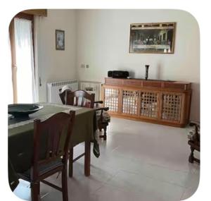 a dining room with a green table and chairs at A un passo dal centro in Salemi