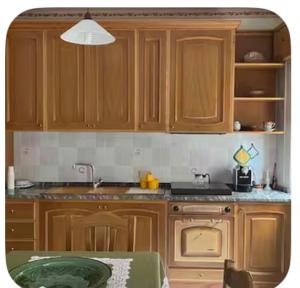 a kitchen with wooden cabinets and a sink and a table at A un passo dal centro in Salemi