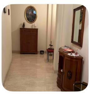 a hallway with a mirror and a wooden dresser at A un passo dal centro in Salemi