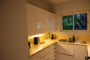 a kitchen with white cabinets and a sink and a window at Seascape Villa in Pointe aux Biches