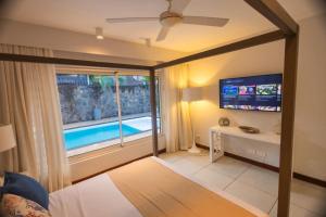 a living room with a view of a swimming pool at Seascape Villa in Pointe aux Biches