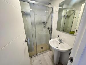 a white bathroom with a shower and a sink at Apartamentos Logroño Centro in Logroño +68 photos
