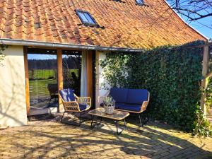 a patio with chairs and a table and a fence at 't Buitenverblijf Erve Punte in Losser
