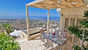 a patio with a table and chairs on a balcony at Breathtaking Panoramic Villa Sea View Infinity Pool in Tala