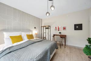 a bedroom with a bed with yellow pillows and a desk at Modernes Design-Apartment am Drachenfels in Bad Honnef am Rhein