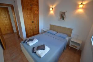 a bedroom with a bed with two towels on it at Villa Cala Lanuza in Alicante