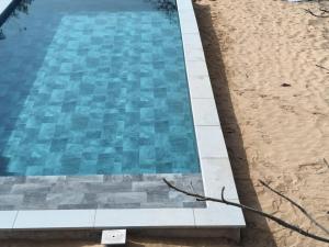 a swimming pool next to a sandy beach at Baobab Beach Villa 2 in Abémé +19 photos
