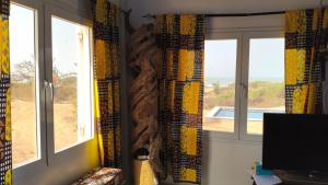 a room with two windows with a view of a field at Baobab Beach Villa 2 in Abémé