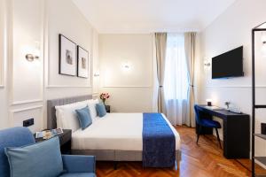a hotel room with a bed and a desk at Piazza del Popolo Boutique GuestHouse in Rome