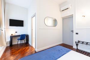 a bedroom with a bed and a desk and a mirror at Piazza del Popolo Boutique GuestHouse in Rome +40 photos