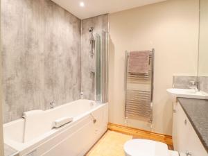 a bathroom with a tub and a toilet and a sink at Old Sorting Office in Cheltenham