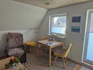a small living room with a table and a chair at Ferienwohnung Röpersberg in Ratzeburg