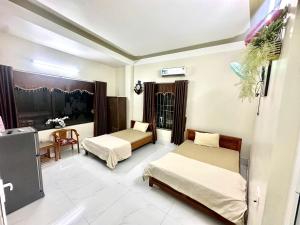 a bedroom with two beds and a table and a chair at Khánh Sạn Trang Thư in Ly Son