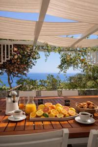 a table with a tray of breakfast foods on it at MEDITERRANEAN SEASONS, VILLA MEDITERRANEA Taormina, Private Pool & Sea View in Taormina