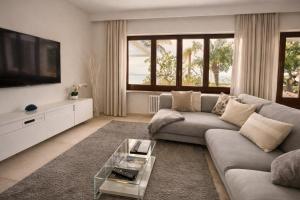 a living room with a couch and a tv at MEDITERRANEAN SEASONS, VILLA MEDITERRANEA Taormina, Private Pool & Sea View in Taormina