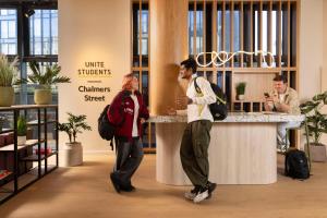 two people standing at a counter in a store at Unite Students - Chalmers Street - The Meadows in Edinburgh