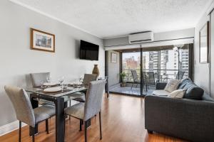 a living room with a dining table and a couch at Isabel Suites Vitacura in Santiago