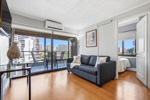 a living room with a couch and a balcony at Isabel Suites Vitacura in Santiago