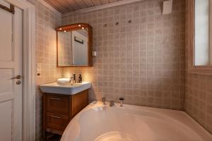 a bathroom with a large tub and a sink at Cosy and central Apartment in Holo