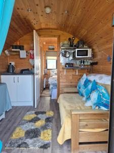 a bedroom in a log cabin with a bed and a kitchen at An Gearasdan in Eoropie
