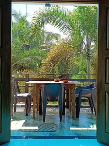 a table and chairs with a table and palm trees at Villa Four Seasons in Mirissa