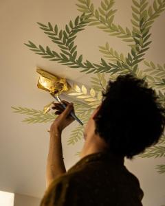 a person cutting a gold leaf on a wall at Hôtel La Cour du 6 in Annecy +38 photos