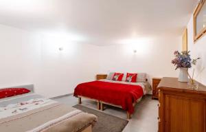 a bedroom with two beds and a red blanket at Le JoliCoeur Parking gratuit Idéal cyclistes Proche Alpe d Huez in Le Bourg-dʼOisans