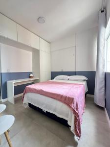 a bedroom with a large bed with a pink blanket at Apartamento no Umarizal in Belém