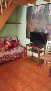 a living room with a couch and a flat screen tv at Cabaña La Perla in Isla Negra