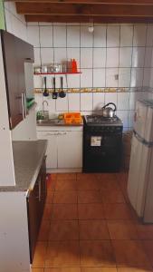 a small kitchen with a stove and a refrigerator at Cabaña La Perla in Isla Negra