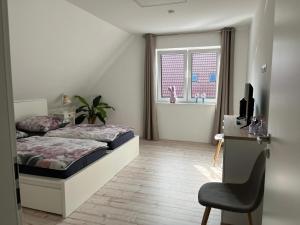 a bedroom with a bed and a desk and a chair at Haus Anna O in Westoverledingen