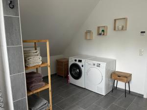 a laundry room with a washing machine and a shelf at Haus Anna O in Westoverledingen